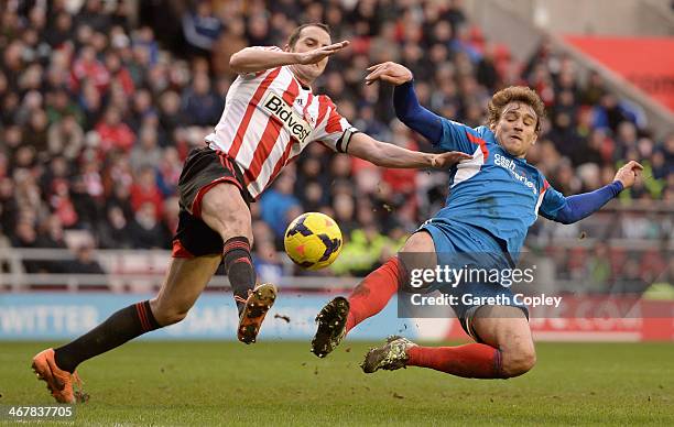 Nikica Jelavic of Hull City and John O'Shea of Sunderland battle for the ball during the Premier League match between Sunderland and Hull City at...