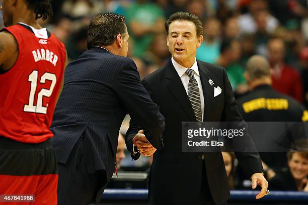 Head coach Mark Gottfried of the North Carolina State Wolfpack shakes hands with head coach Rick Pitino of the Louisville Cardinals prior to their...
