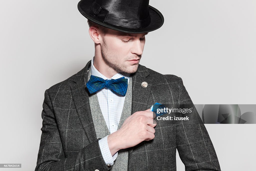 Elegant young man wearing tweed jacket, bow tie and bowler