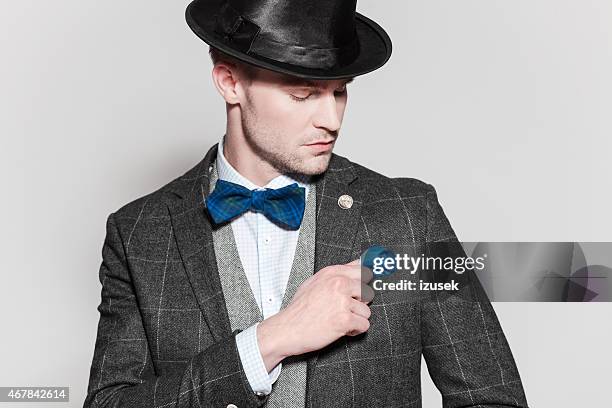 elegant young man wearing tweed jacket, bow tie and bowler - hat and suit stock pictures, royalty-free photos & images