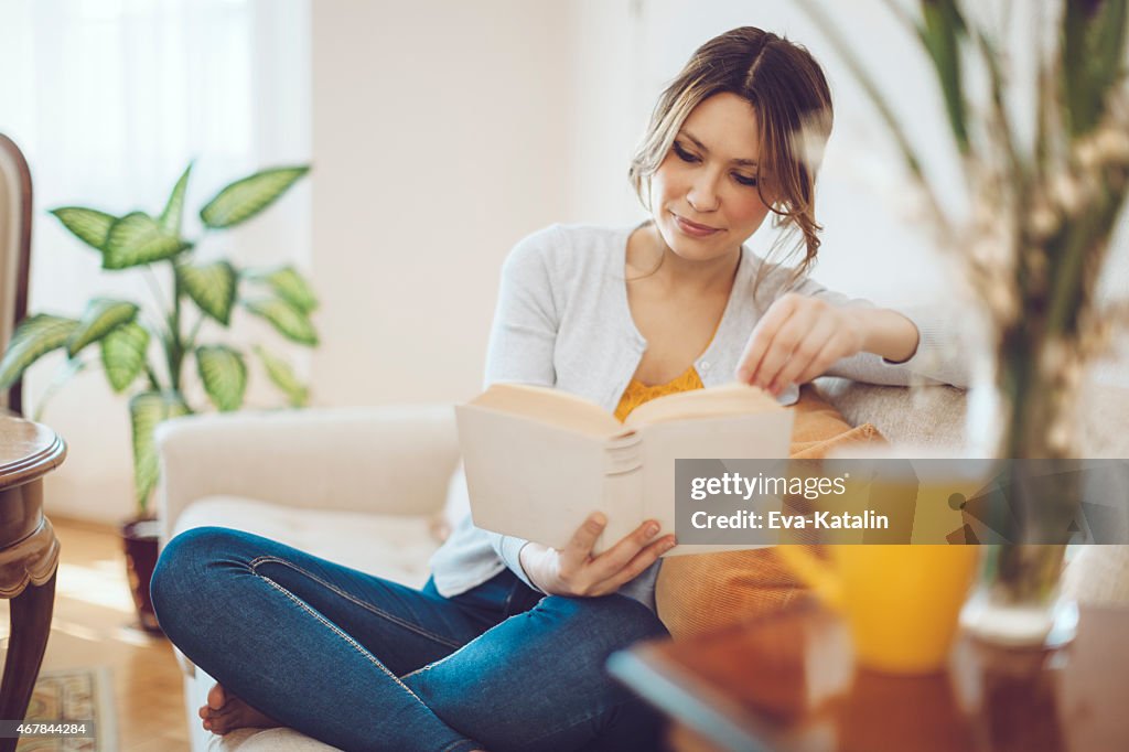 Schöne latin Frau liest ein Buch wie zu Hause fühlen