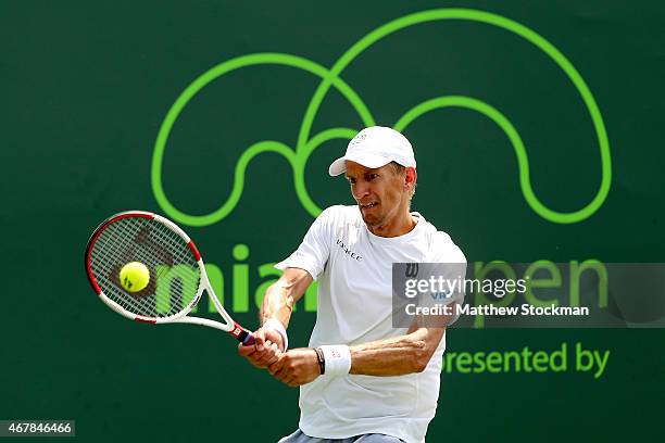 Jarrko Nieminen of Finland returns a shot to Leonardo Mayer of Argentina during day 5 of the Miami Open Presented by Itau at Crandon Park Tennis...