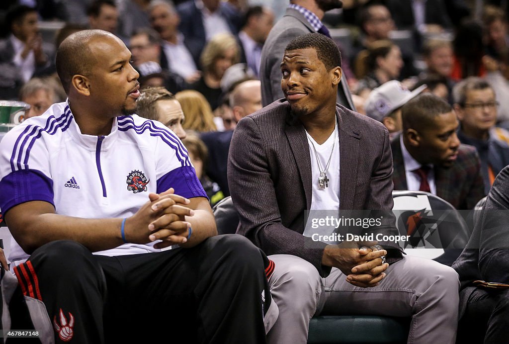 Chuck Hayes (44) and Kyle Lowry (7) of the Toronto Raptors talk on the bench