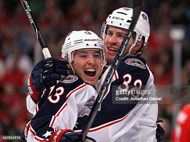 Cam Atkinson of the Columbus Blue Jackets gets a hug from teammate Boone Jenner after s coring a goal in the first period against the Chicaho...