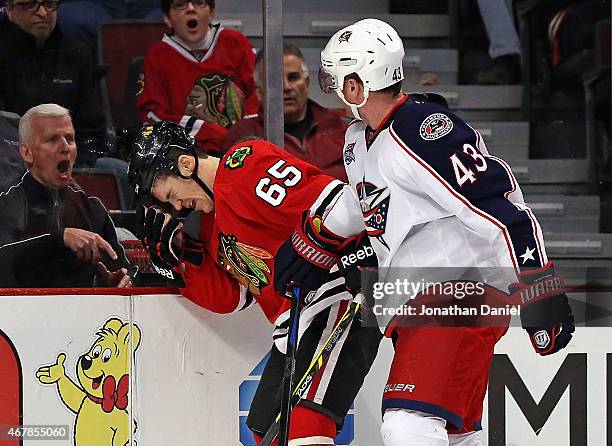 Fan yells as Andrew Shaw of the Chicago Blackhawks reacts after being hit by Scott Hartnell of the Columbus Blue Jackets at the United Center on...