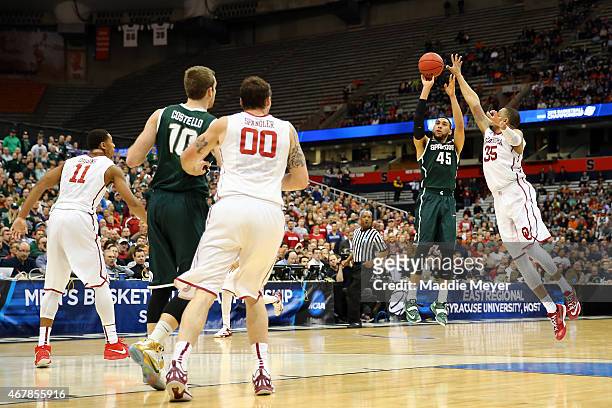 Denzel Valentine of the Michigan State Spartans shoots a three pointer in the second half of the game against TaShawn Thomas of the Oklahoma Sooners...
