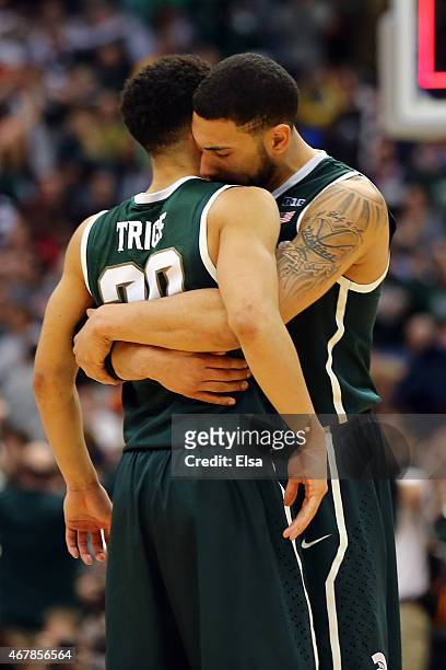 Denzel Valentine of the Michigan State Spartans celebrates with teammate Travis Trice after defeating the Oklahoma Sooners 62 to 58 during the East...