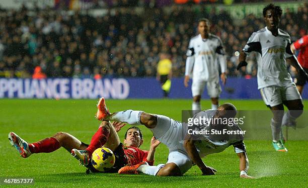 Cardiff player Peter Whittingham is challenged by Ashley Williams of Swansea during the Barclays Premier League match between Swansea City and...