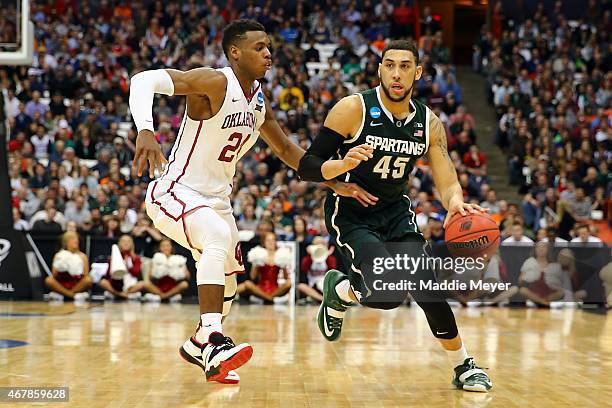 Denzel Valentine of the Michigan State Spartans drives against Buddy Hield of the Oklahoma Sooners during the East Regional Semifinal of the 2015...