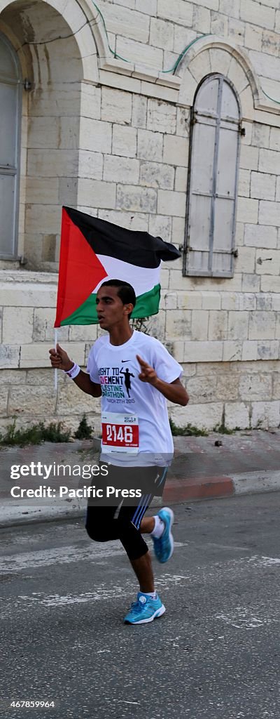 A marathon runner holds a Palestinian flag in the Right to...