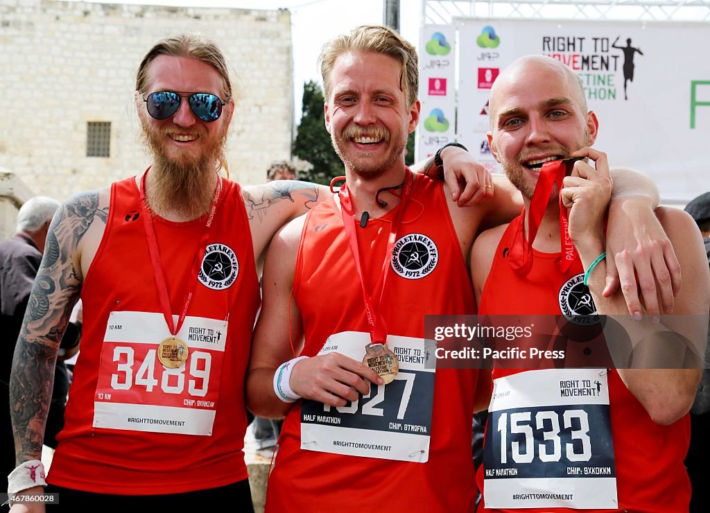 Three marathon runners pose for pictures after having...