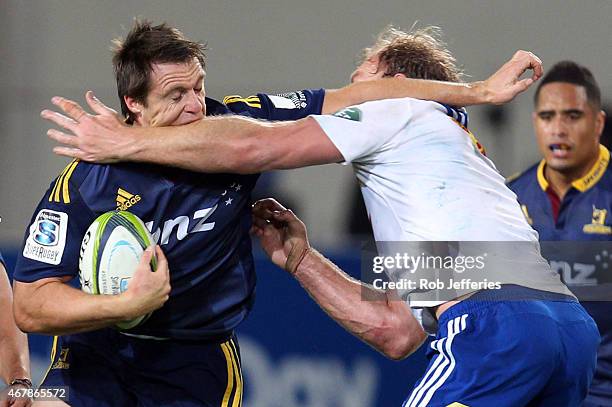 Ben Smith of the Highlanders is hit in a high tackle by Schalk Burger during the round seven Super Rugby match between the Highlanders and the...