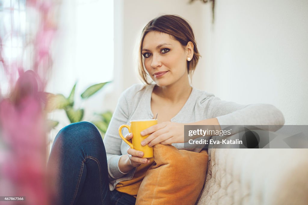 Brunette Frau Entspannung zu Haus'und Trinken Kaffee