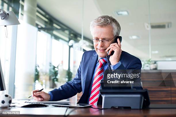 empresário responder a uma chamada de telefone - landline phone imagens e fotografias de stock