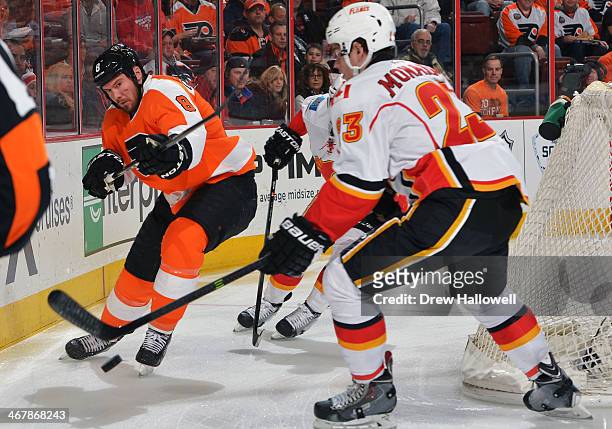 Nicklas Grossmann of the Philadelphia Flyers clears the puck away from Sean Monahan of the Calgary Flames at the Wells Fargo Center on February 8,...