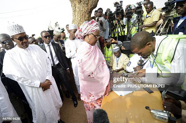 The main opposition All Progressives Congress presidential candidate, Mohammadu Buhari , watches his wife, Aisha register to vote on March 28, 2015...