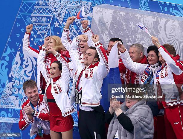 Ksenia Stolbova and Fedor Klimov of Russia celebrate with teammates and coaches after receiving their score during the Figure Skating Team Pairs Free...