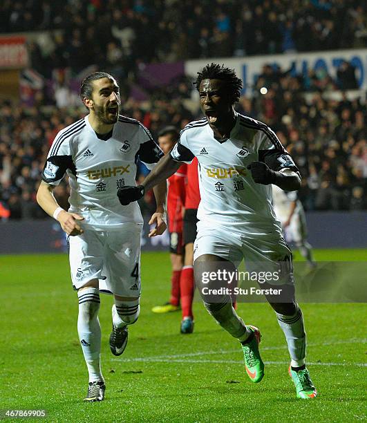 Swansea striker Wilfried Bony celebrates with Chico Flores after scoring the third goal during the Barclays Premier League match between Swansea City...