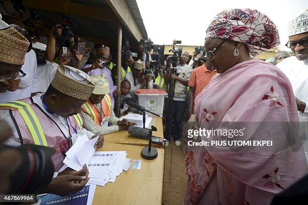 Election workers check documents of the wife of main opposition All Progressives Congress presidential candidate, Mohammadu Buhari, Aisha, on March...