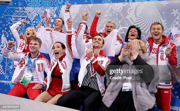 Ksenia Stolbova and Fedor Klimov of Russia celebrate with teammates and coaches after receiving their score during the Figure Skating Team Pairs Free...