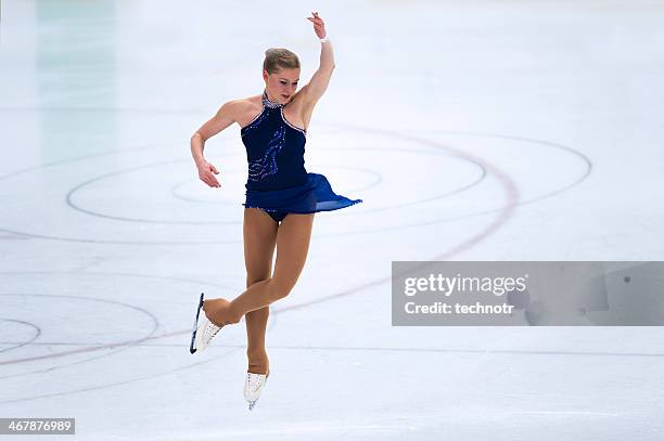 weibliche skater performing springen während figure skating competition - woman ice stock-fotos und bilder