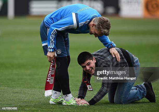 Young streaker runs past Bastian Schweinsteiger of Germany during a Germany training session ahead of their Euro 2016 Qualifier against Georgia at...