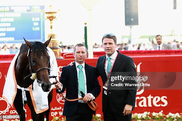 Former England international footballer Michael Owen and trainer Tom Dascombe pose with Brown Pather after winning Dubai Gold Cup during the Dubai...