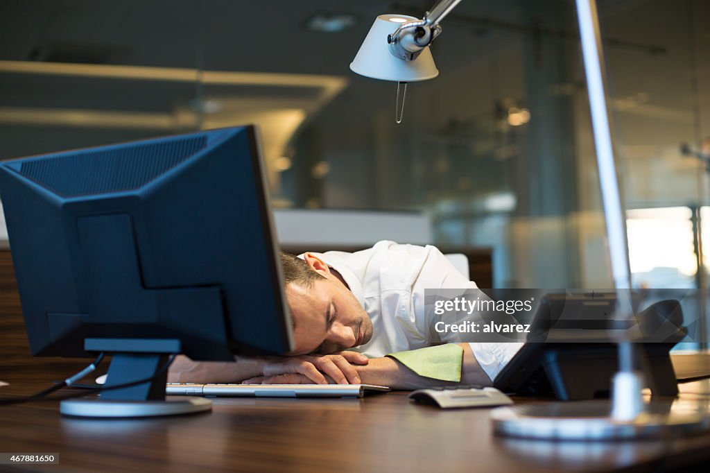 Overworked businessman sleeping at his desk