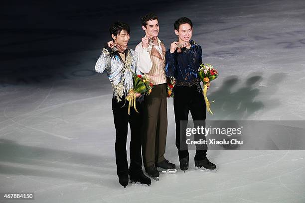 Second place winner Yuzuru Hanyu of Japan, first place winner Javier Fernandez of Spain, third place winner Denis Ten of Kazakhstan pose for photo...