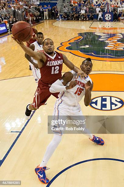 Trevor Releford of the Alabama Crimson Tide shoots the ball over Will Yeguete of the Florida Gators during the first half of the game at the Stephen...