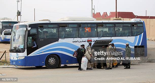 Members of the Iraqi Popular Mobilisation units ride in a bus outside the western entrance of the city of Tikrit, as they are relocated back to...