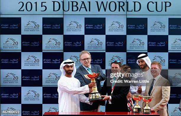 Former England international footballer Michael Owen raises the trophy after winning the Dubai Gold Cup with Brown Pather during the Dubai World Cup...