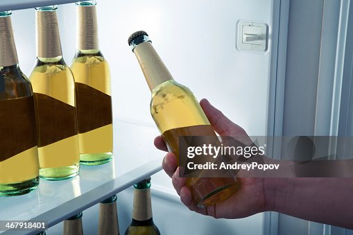 Man taking a beer bottle from a fridge Man taking a beer bottle from a fridge