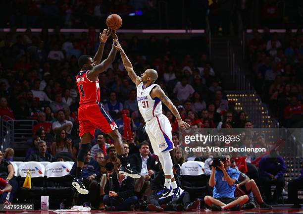 Dahntay Jones of the Los Angeles Clippers challenges the outside jump shot of Martell Webster of the Washington Wizards during the NBA game at...