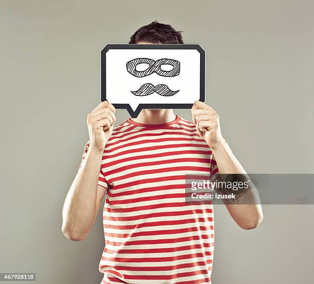 young man holding speech bubble with mustache and mask - förklädnad bildbanksfoton och bilder