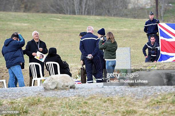 Relatives stand at a monument to honour the victims of Germanwings flight 4U9525 in front of the mountains near the crash site on March 26, 2015 in...