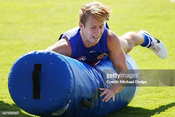 Lachie Hunter tackles a tackle bag during a Western Bullldogs AFL training session at Victoria University Whitten Oval on February 9, 2014 in...