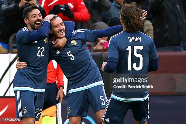 Federico Mancuello of Argentina celebrates his second half goal against El Salvador with teammates Ezequiel Lavezzi and Lucas Orban during an...