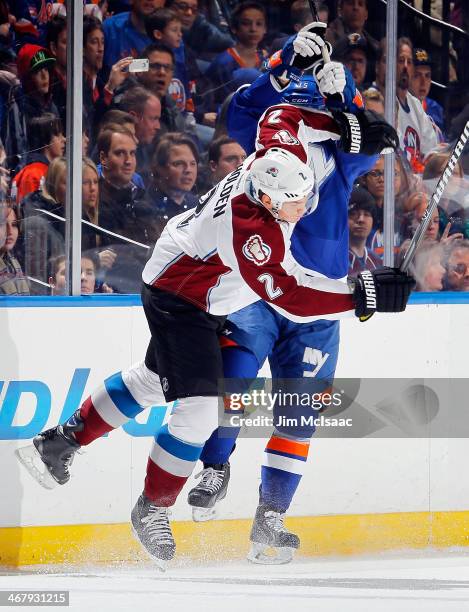 Cal Clutterbuck of the New York Islanders collides with Nick Holden of the Colorado Avalanche on February 8, 2014 at Nassau Coliseum in Uniondale,...