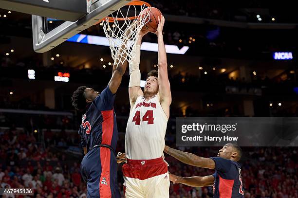 Frank Kaminsky of the Wisconsin Badgers goes up for a dunk against Stanley Johnson of the Arizona Wildcats in the second half during the West...