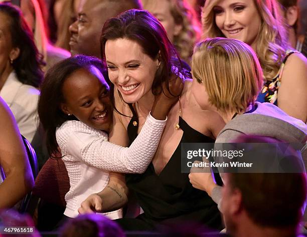 Actress Angelina Jolie hugs Zahara Marley Jolie-Pitt and Shiloh Nouvel Jolie-Pitt after winning award for Favorite Villain in 'Maleficent' during...