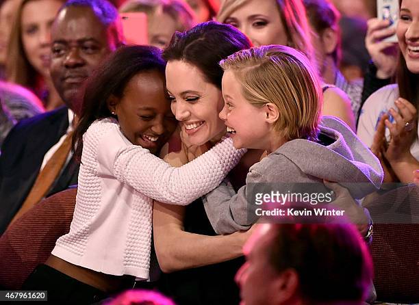 Actress Angelina Jolie hugs Zahara Marley Jolie-Pitt and Shiloh Nouvel Jolie-Pitt after winning award for Favorite Villain in 'Maleficent' during...