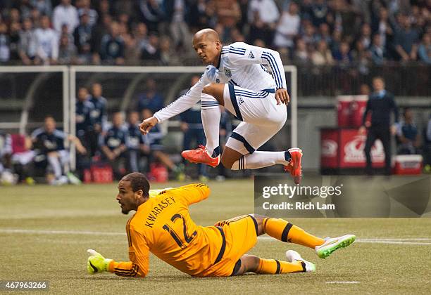 Robert Earnshaw of the Vancouver Whitecaps FC jumps over goalkeeper Adam Kwarasey of the Portland Timbers while watching his shot go in for the game...