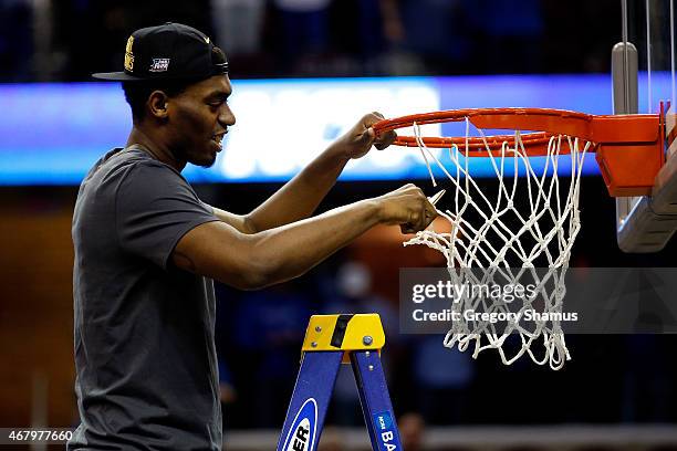 Dakari Johnson of the Kentucky Wildcats cuts down the net after defeating the Notre Dame Fighting Irish during the Midwest Regional Final of the 2015...