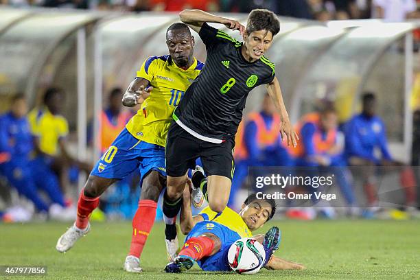 Jurgen Damm of Mexico is brought down by Walter Ayovi and Christian Noboa of Ecuador during a friendly match between Mexico and Ecuador at Memorial...