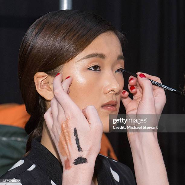 Model prepares before the Mara Hoffman show during Mercedes-Benz Fashion Week Fall 2014 at The Salon at Lincoln Center on February 8, 2014 in New...