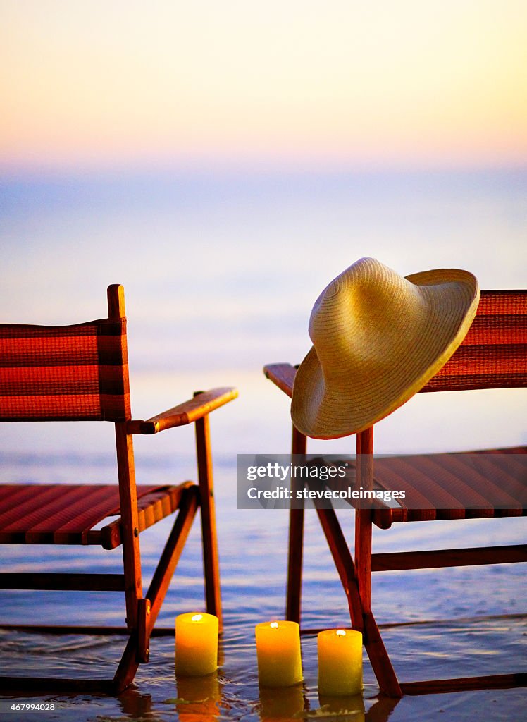 Wooden beach chairs on beach at sunset or sunrise,