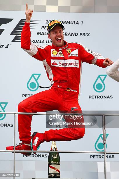 Sebastian Vettel of Germany and Ferrari celebrates on the podium after winning the Malaysia Formula One Grand Prix at Sepang Circuit on March 29,...