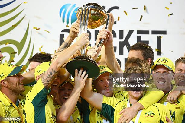 The Australia team cheer as they lift the world cup trophy as they celebrate victory during the 2015 ICC Cricket World Cup final match between...