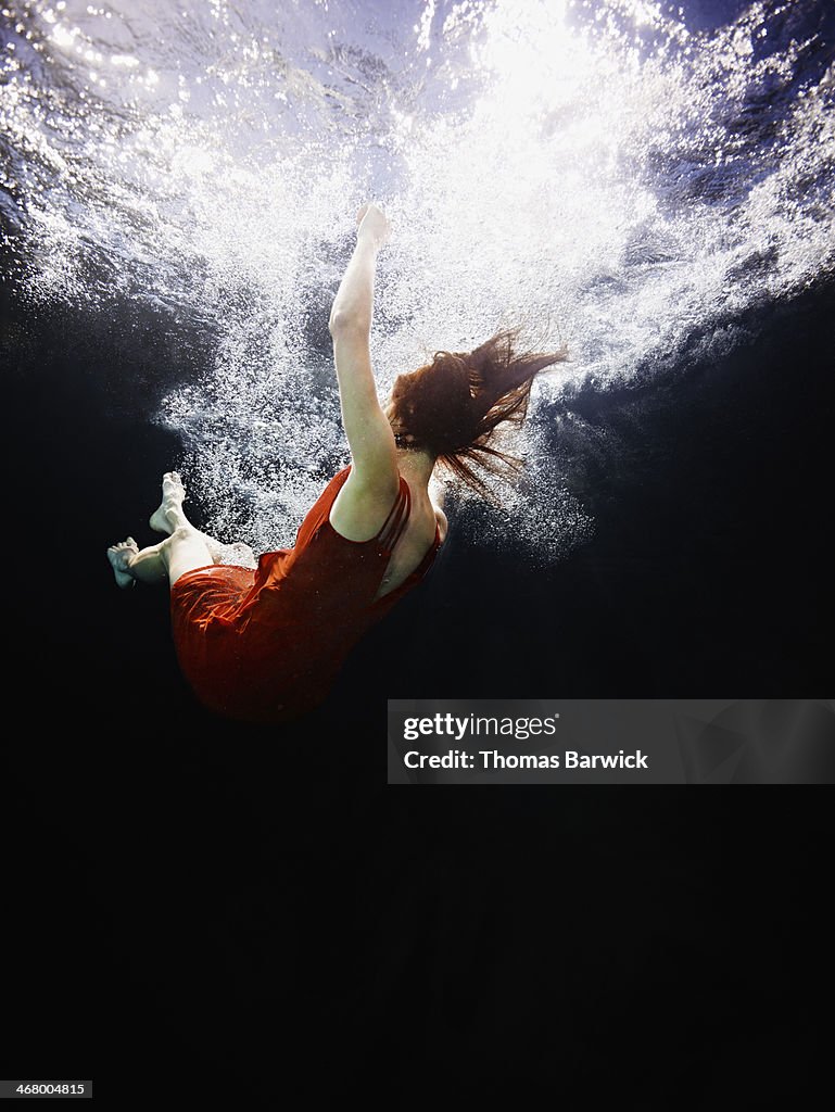 View from underwater of woman falling into water